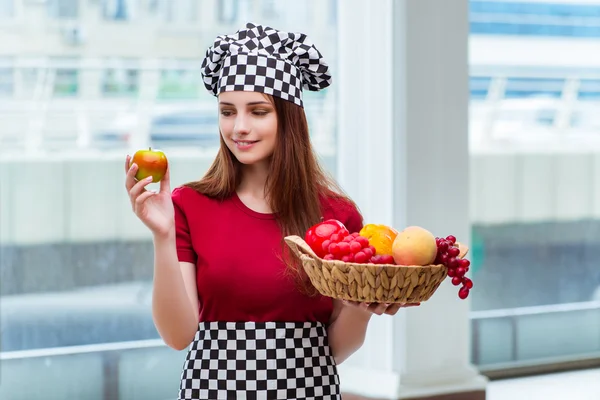 Jovem cozinheiro com frutas na cozinha — Fotografia de Stock