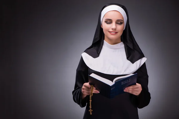 Religieuze nun in religie concept tegen de donkere achtergrond — Stockfoto