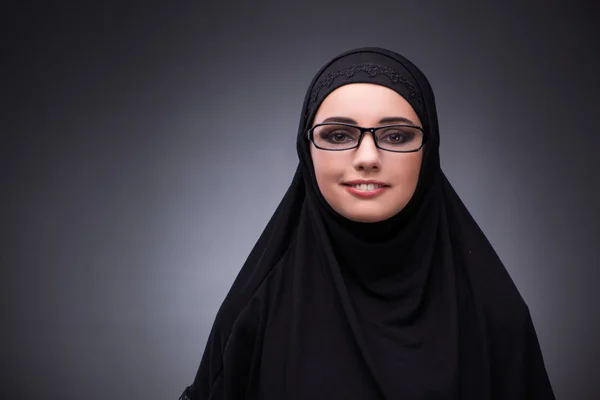 Mulher muçulmana em vestido preto contra fundo escuro — Fotografia de Stock