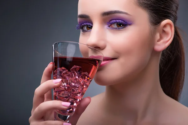Милая женщина пьет красный коктейль — стоковое фото