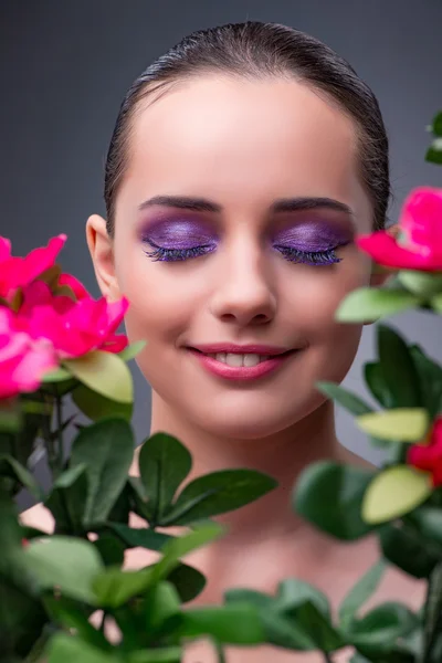 Jovem com flores no conceito de beleza — Fotografia de Stock