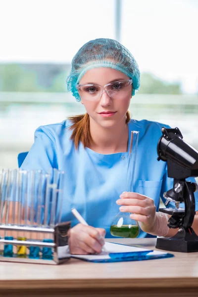 Junge Studentin arbeitet im Labor mit chemischen Lösungen — Stockfoto