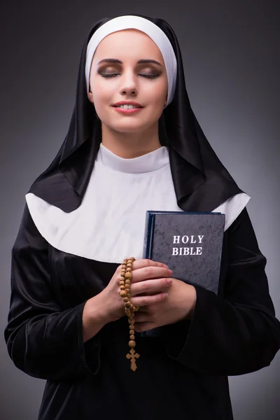 Religieuze nun in religie concept tegen de donkere achtergrond — Stockfoto