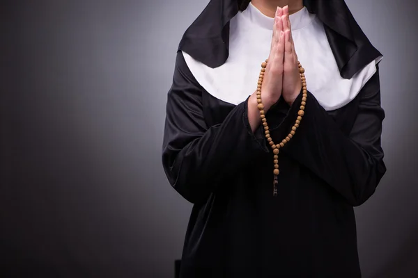 Religieuze nun in religie concept tegen de donkere achtergrond — Stockfoto