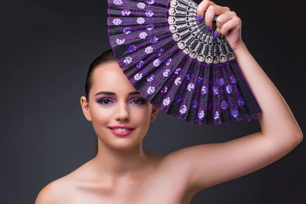 Nice woman with fan against gray background — Stock Photo, Image