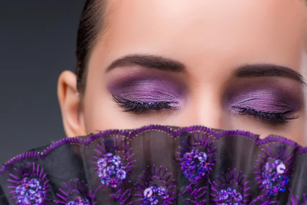 Bella donna con ventilatore contro sfondo grigio — Foto Stock