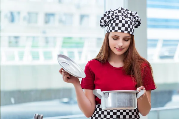 Молодая домохозяйка готовит суп на кухне — стоковое фото