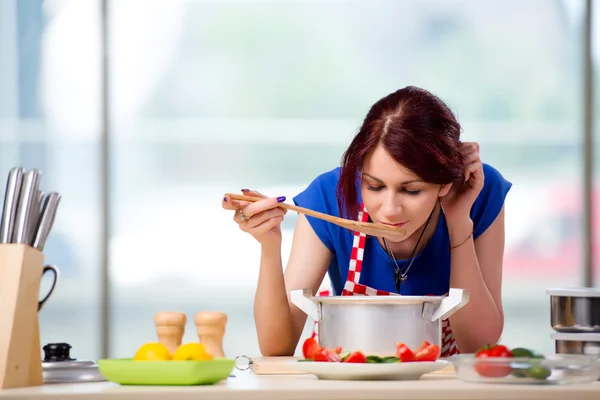 Vrouwelijke kok bereiden soep in fel verlicht keuken — Stockfoto