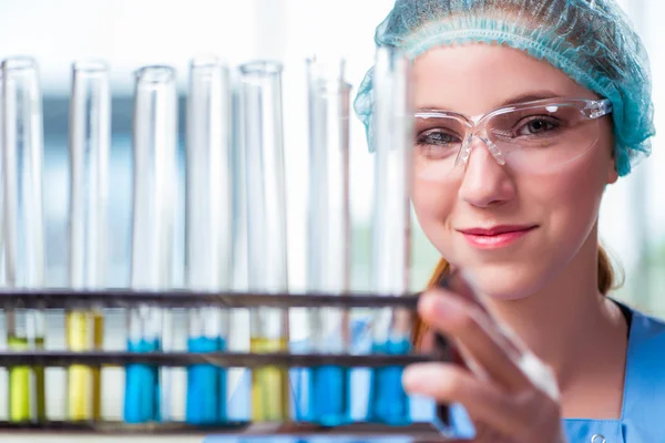 Jovem estudante trabalhando com soluções químicas em laboratório — Fotografia de Stock