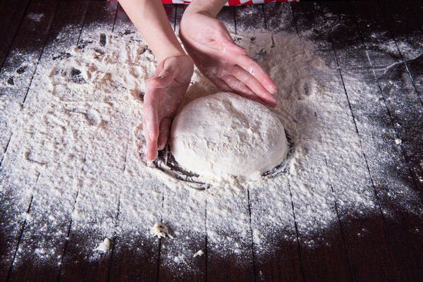 Cook preparing dough for baking in the kitchen