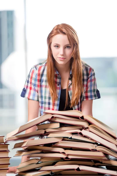 Estudante com pilhas de livros se preparando para exames — Fotografia de Stock