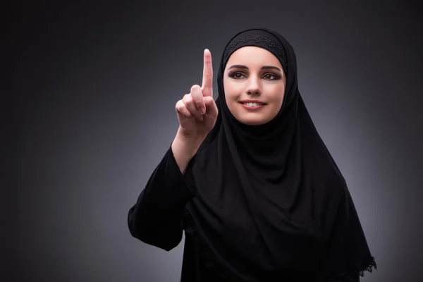 Muslimische Frau in schwarzem Kleid vor dunklem Hintergrund — Stockfoto