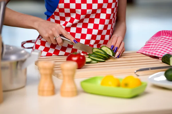 Kvinna förbereder sallad i köket — Stockfoto