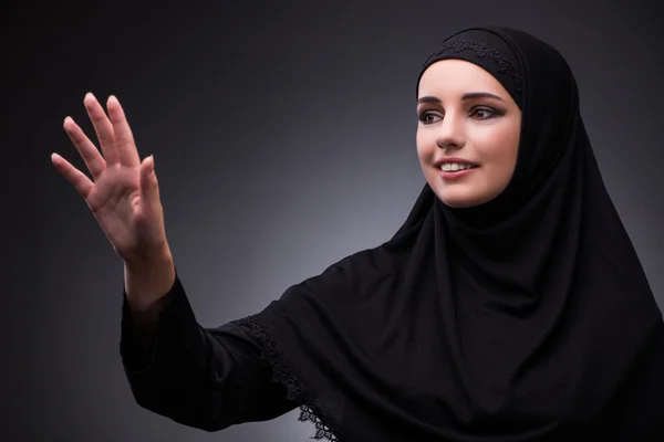 Muslimische Frau in schwarzem Kleid vor dunklem Hintergrund — Stockfoto