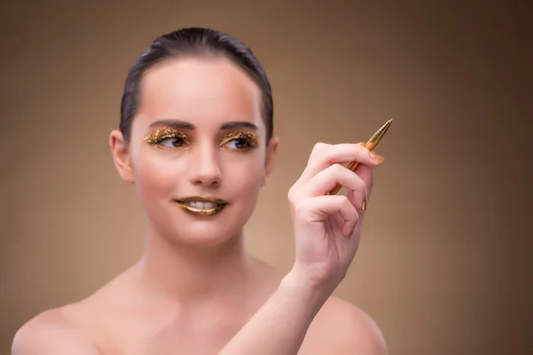 Mulher com caneta dourada no conceito de moda — Fotografia de Stock