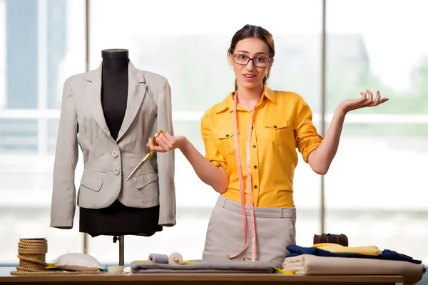 Mulher alfaiate trabalhando em roupas novas — Fotografia de Stock