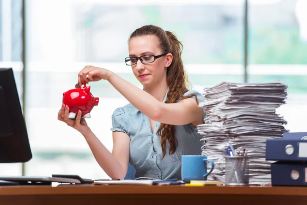 Junge Geschäftsfrau mit Sparschwein im Büro — Stockfoto