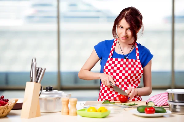 Kvinna förbereder sallad i köket — Stockfoto