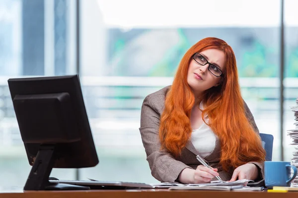 빨강 머리 실업 사무실에서 그녀의 책상에 앉아 — 스톡 사진
