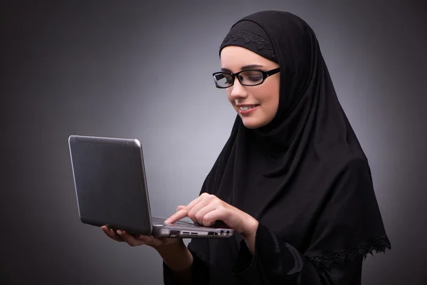 Muslim woman in black dress against dark background — Stock Photo, Image