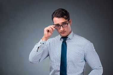 Gri bir arka plana dayanır yakışıklı işadamı