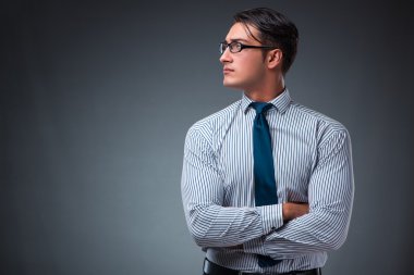 Gri bir arka plana dayanır yakışıklı işadamı