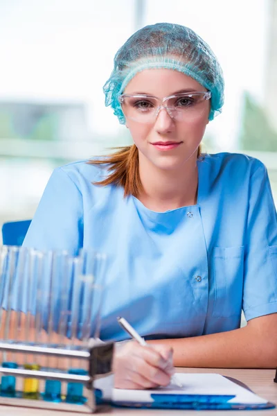 Junge Studentin arbeitet im Labor mit chemischen Lösungen — Stockfoto