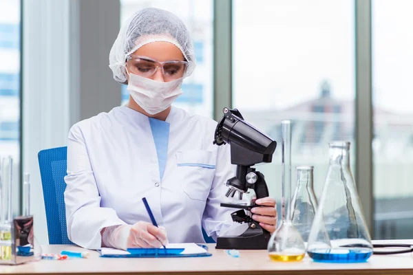 Jeune étudiant travaillant avec des solutions chimiques en laboratoire — Photo