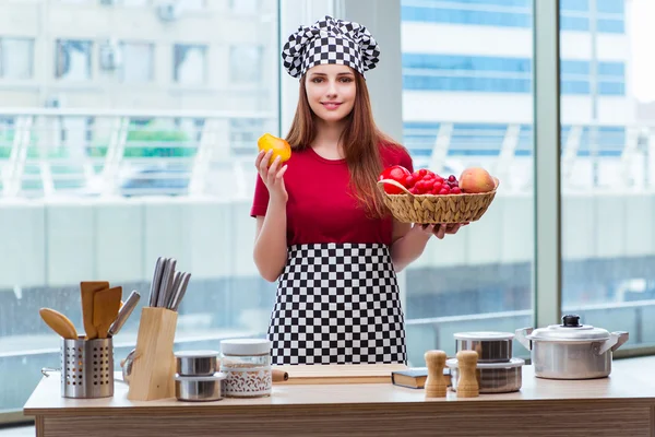 Jovem cozinheiro com frutas na cozinha — Fotografia de Stock