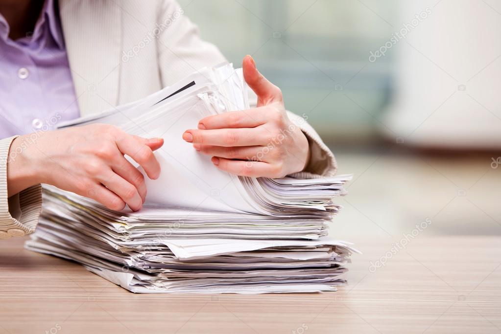 Businesswoman working with stack of papers