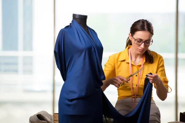 Mulher alfaiate trabalhando em roupas novas — Fotografia de Stock