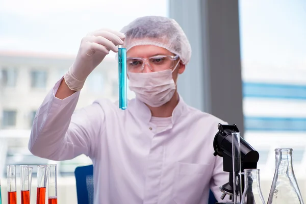 Человек, работающий в химической лаборатории над научным проектом — стоковое фото
