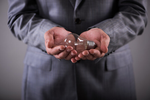 Businessman holding light bulb in creativity concept