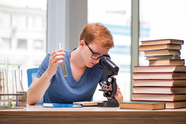 Jovem estudante cansado e exausto se preparando para o exame de química — Fotografia de Stock