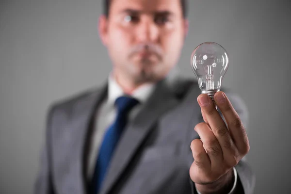 Businessman holding light bulb in creativity concept — Stock Photo, Image