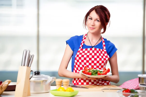 Kvinna förbereder sallad i köket — Stockfoto