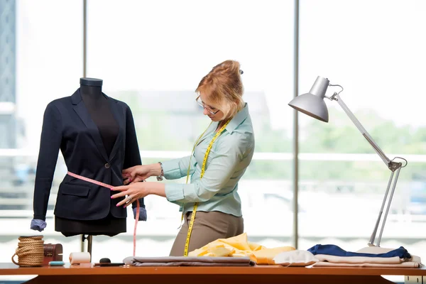 Mulher alfaiate trabalhando em roupas novas — Fotografia de Stock