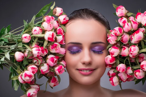 Νεαρή γυναίκα με λουλούδια στην έννοια της ομορφιάς — Φωτογραφία Αρχείου
