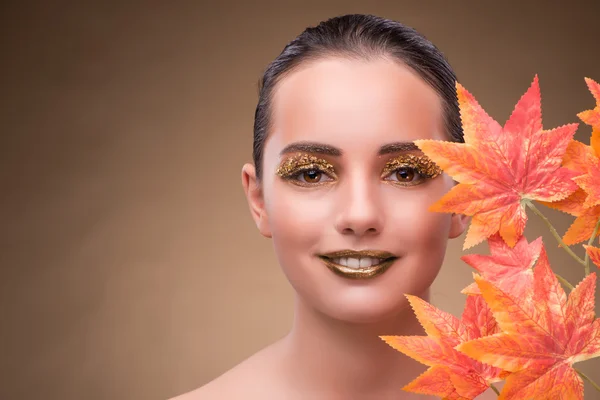 Jovem com folhas secas de outono — Fotografia de Stock