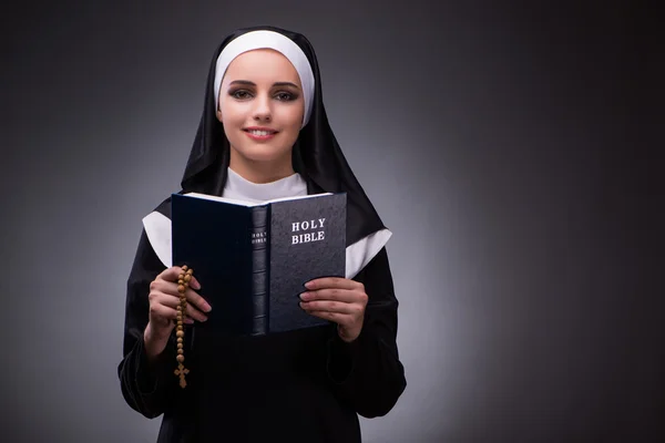 Religieuze nun in religie concept tegen de donkere achtergrond — Stockfoto