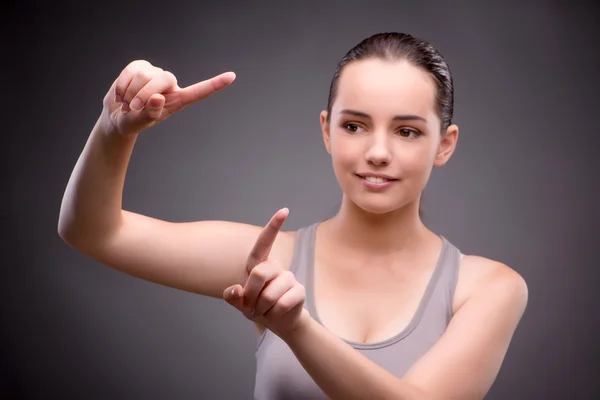 Vrouw in sport concept knoppen in te drukken — Stockfoto