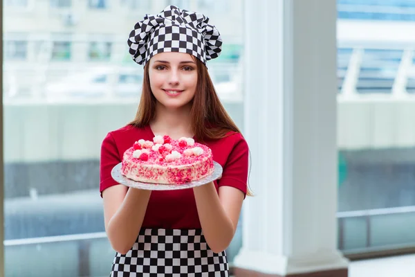 Ung hemmafru baka tårta i köket — Stockfoto