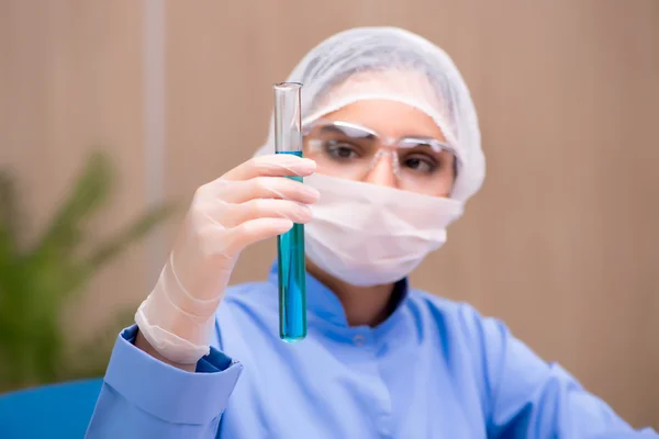 Químico de laboratorio que trabaja con microscopio y tubos — Foto de Stock