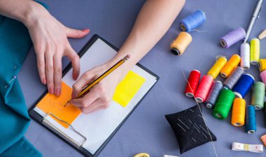 Kadın terzi dikiş dikmek için dikiş dikiyor.