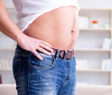 Diyet konseptinde fazladan ağırlık çeken adam.