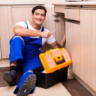 Mutfakta çalışan genç tamirci.