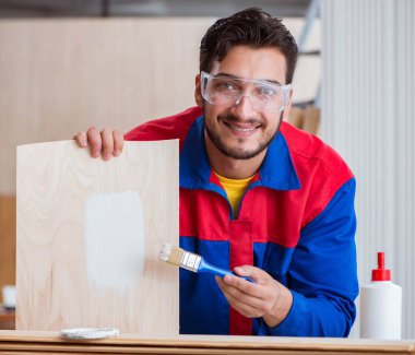 Tamirci, boyayla uğraşan marangoz.