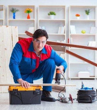 Genç marangoz ahşap kalaslarla çalışıyor.