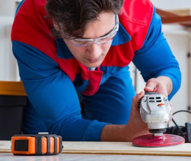 Genç marangoz ahşap kalaslarla çalışıyor.