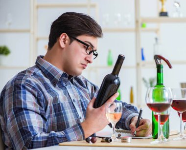 Profesyonel şarap garsonu kırmızı şarap tadıyor.